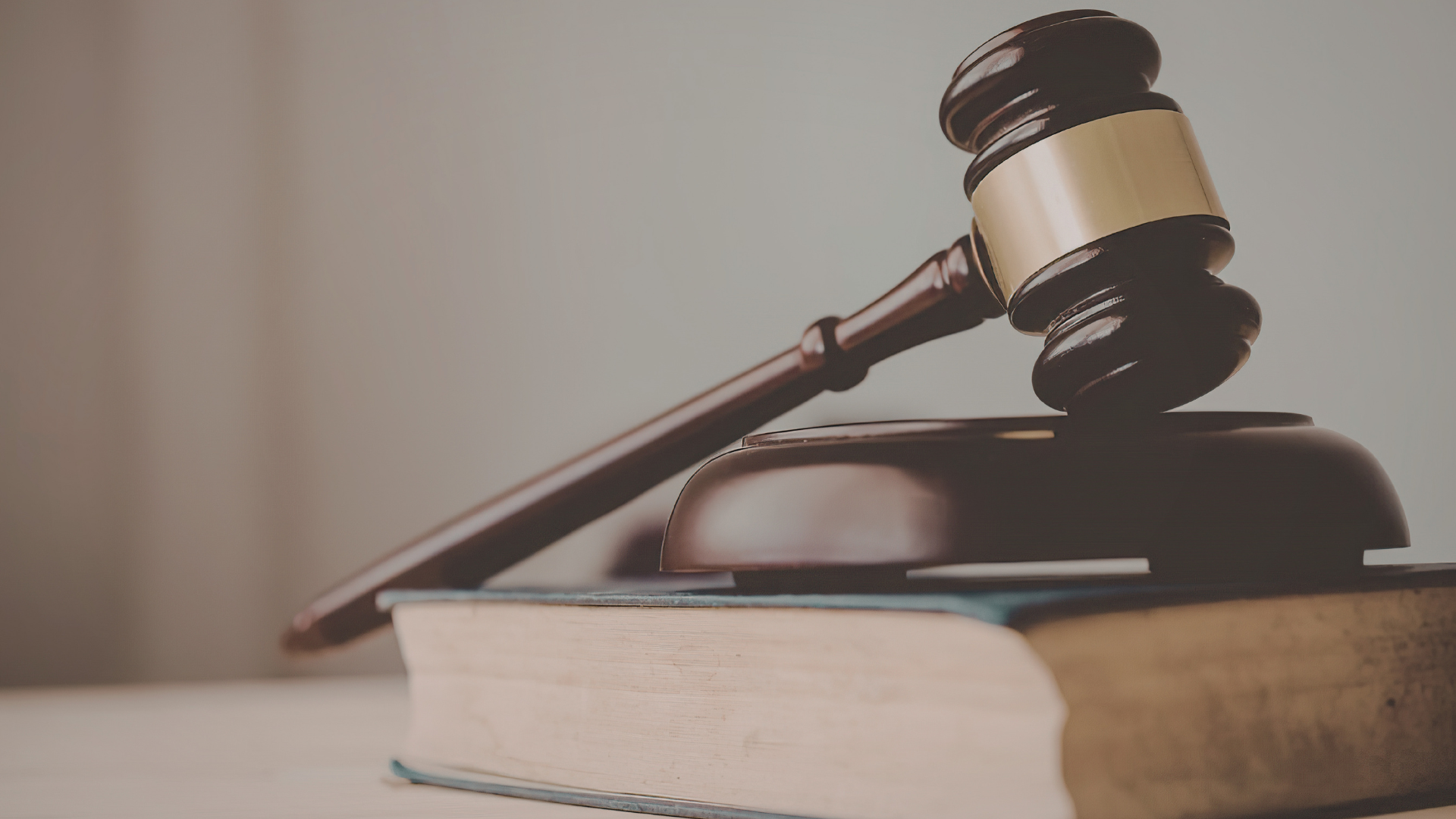 Judge’s gavel resting on law books, representing the legal and regulatory requirements of AML/CTF compliance for real estate agencies.