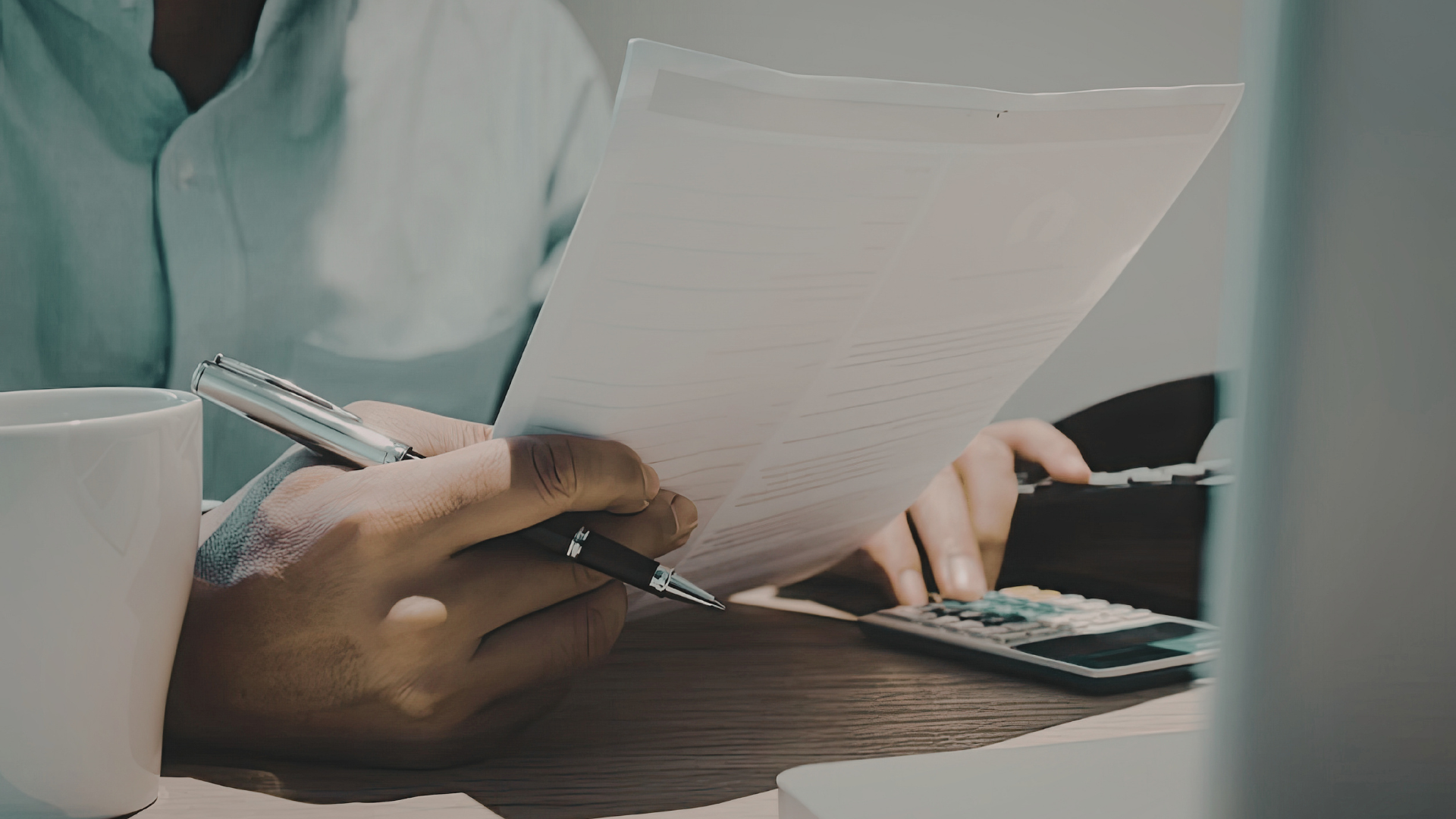 Real estate professional reviewing client documents and calculations for AML/CTF compliance.